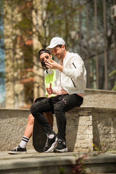 Zwei gut aussehende Freunde überprüfen die Selfies, die sie gemacht haben - Foto, Bild