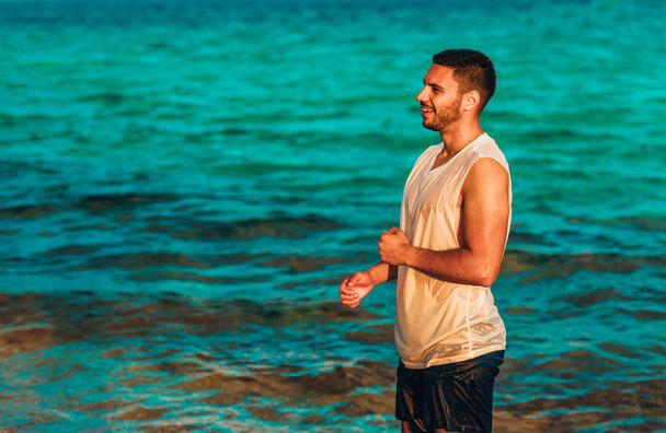 Πορτρέτο του όμορφου άνδρα απολαμβάνοντας τις διακοπές στην παραλία - Φωτογραφία, εικόνα
