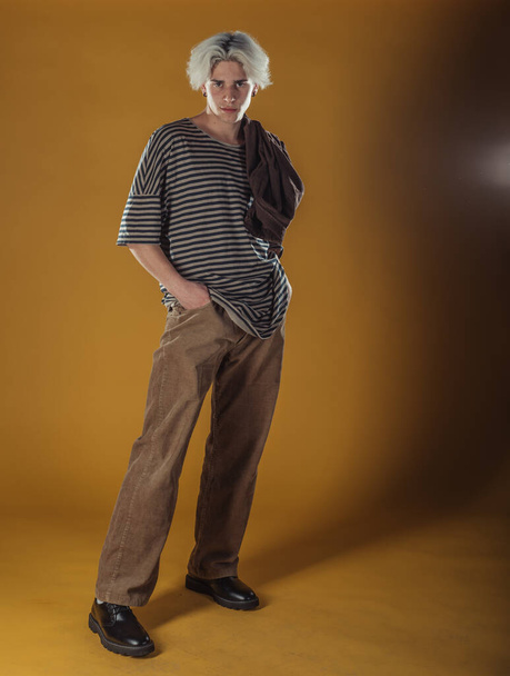 Portrait of a smart young man standing against yellow backgroun - Fotó, kép