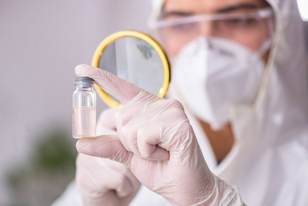 Молодий хімік-чоловік працює в лабораторії під час пандемії
 - Фото, зображення