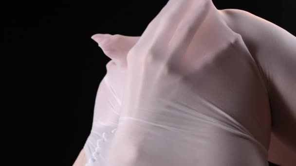 Schieten van vrouwelijke handen onder witte panty 's op zwarte achtergrond - Video