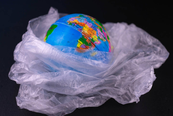   |123Mock Planet Plastic Bag Black Background Concept Saving Our Planet Earth - Foto, imagen