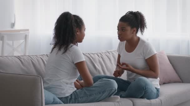 Joven mujer afroamericana molesta peleando con adolescente negra gruñona, contando sobre su mal comportamiento - Imágenes, Vídeo