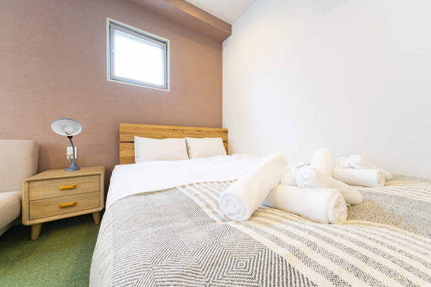Helles Schlafzimmer mit weißen Bettlaken im Zimmer - Foto, Bild