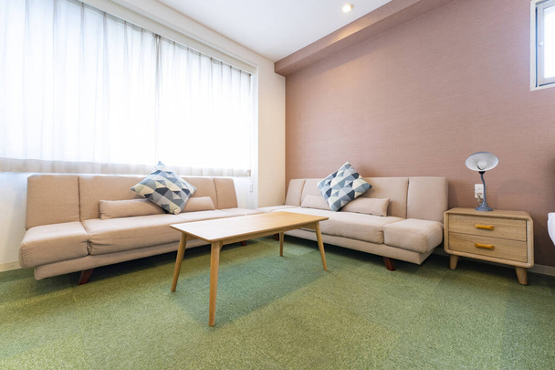 Fényes belső tér kanapéval és párnákkal, szállodai szoba - Fotó, kép
