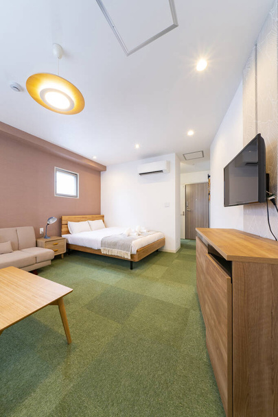 TV en bank in lichte kamer, hotelkamer - Foto, afbeelding