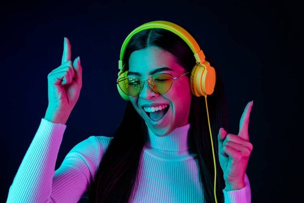 Photo of young excited girl happy positive smile dance nightclub headphones hipster isolated over neon color background - Foto, immagini