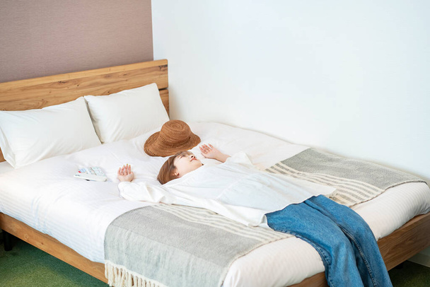 Aziatische vrouw ontspannen in een bed van hotel - Foto, afbeelding