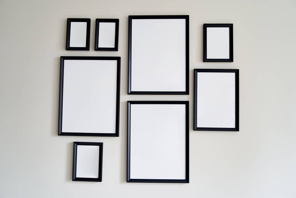 Different size framed photos hanging on the gray wall. High quality photo - Photo, Image