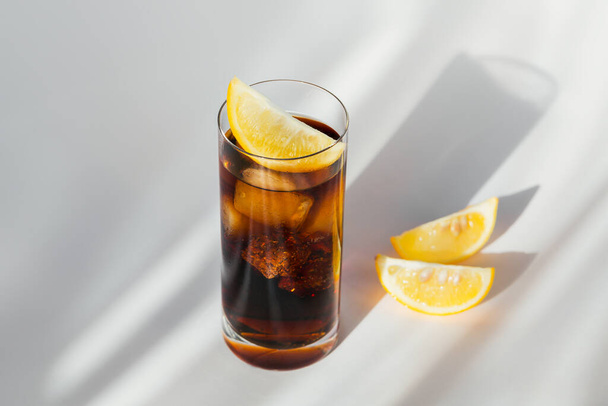Glass of cola with ice and lemon - Foto, afbeelding