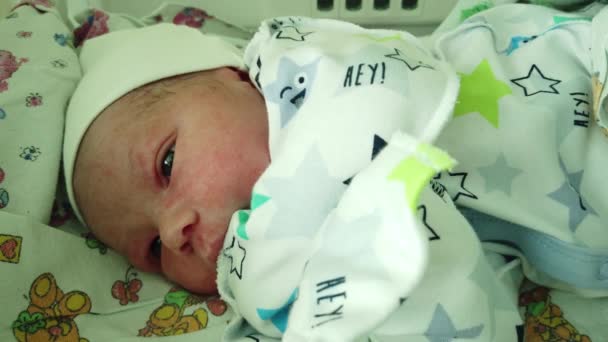 Pasgeboren baby in het kraamziekenhuis. De baby is net geboren en hij was omgekleed in schone kleren.. - Video
