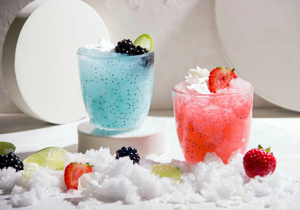 Berry verano frambuesa y cócteles de mora sobre hielo sobre un fondo blanco. Junto a los ingredientes - Foto, imagen