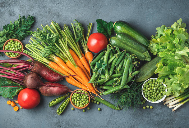 Una variedad de verduras frescas sobre un fondo gris-azul. Vista superior, espacio de copia. Imagen teñida. - Foto, imagen