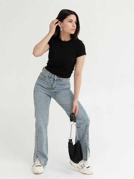 beautiful girl in fashionable jeans and with a bag in her hands - Photo, Image