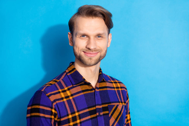 Portrait of attractive content cheerful guy wearing checked shirt isolated over vibrant blue color background - Foto, immagini