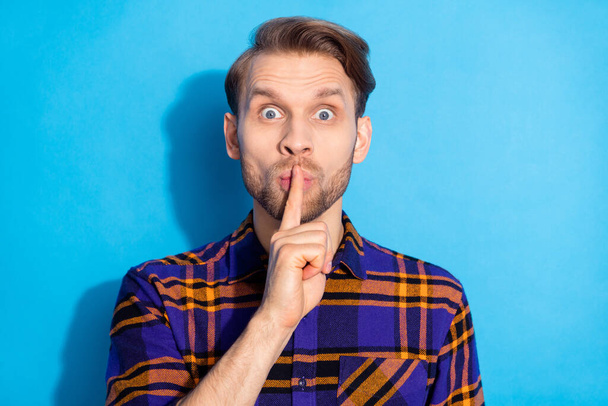 Photo of worried person finger covering lips do not tell staring camera isolated on blue color background - Valokuva, kuva