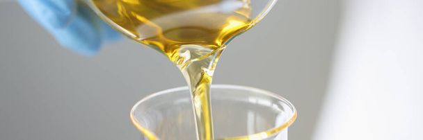 Forscher lässt goldene Flüssigkeit in Chemiekolben abfließen - Foto, Bild