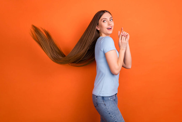 Profile photo of impressed brown hairdo young lady look empty space wear blue t-shirt isolated on vivid orange color background - 写真・画像
