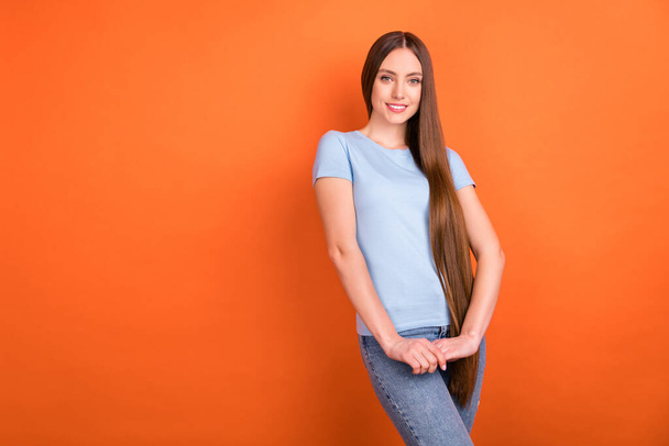 Photo of sweet brown hairdo young lady hold hands wear blue t-shirt isolated on vivid orange color background - Foto, Bild