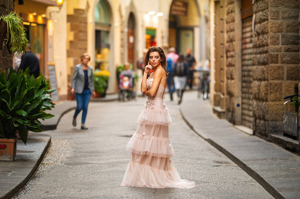 ピンクのウェディングドレスを着た花嫁がイタリアのフィレンツェを歩く. - 写真・画像
