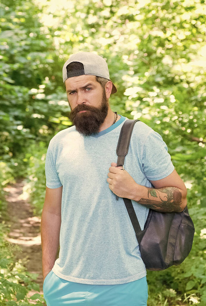 Relaxing hiking Experience. Bearded man carry backpack. ready for camping. male tourist wear cap. sport and fitness clothes. Confident and handsome brutal man. brutal caucasian hipster with moustache - Foto, Bild