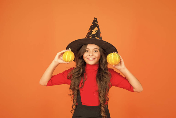happy kid in witch hat costume to halloween with small yellow pumpkin, halloween food - Фото, изображение