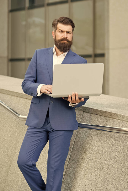 Freelance worker in formal fashion suit work online using laptop computer device modern technology urban outdoors, freelancing - Photo, image