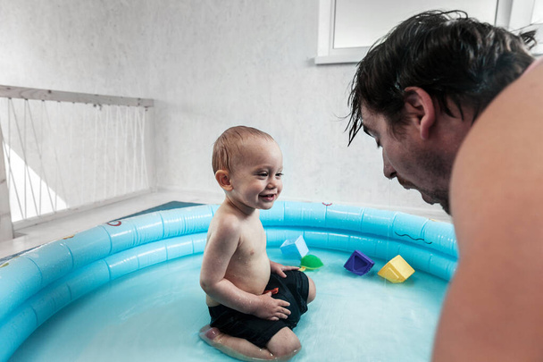 father with toddler son plays in the pool in the flat - Photo, Image