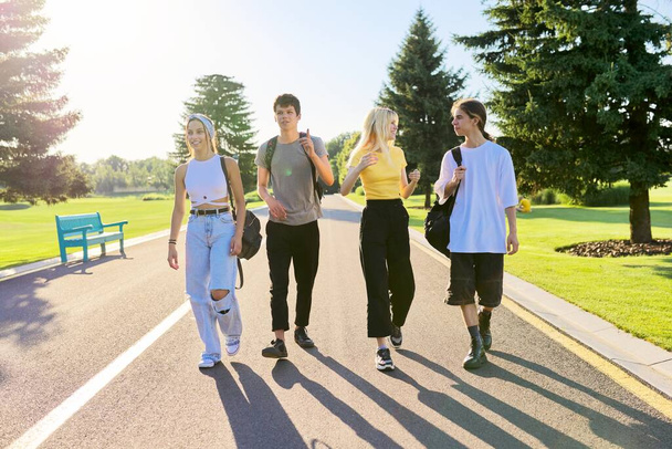 Outdoor, four teenagers walking together on road - Zdjęcie, obraz
