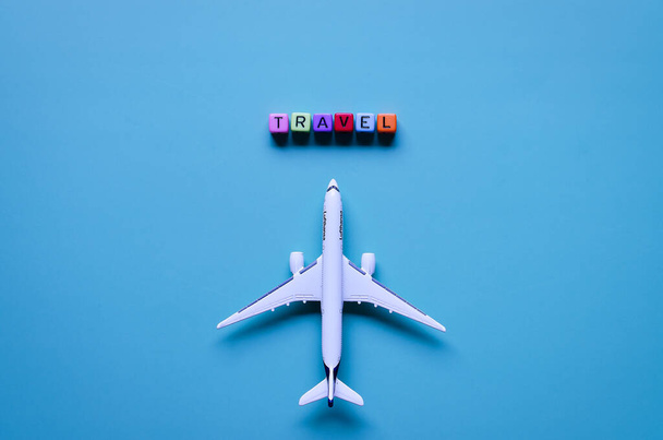 Portoro, Slovenia. 07.04.2021. Coronavirus concept. Top view of toy airplane close up, cube beads with words "Travel", "Yes". Travelling with face mask. Creative ideas of prevent COVID - 19.  - Foto, Imagem