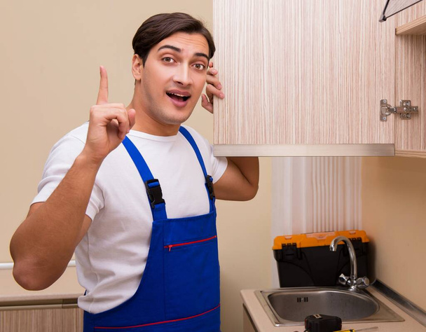 Giovane uomo assemblaggio mobili da cucina - Foto, immagini