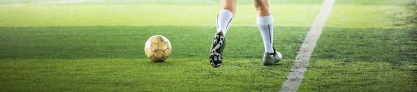 Voetbalspeler lopen met wazige bal op groene kunstgras. Voetbalspeler op de voetbalacademie. - Foto, afbeelding