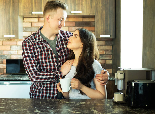 Young happy lovely couple have breakfast in the early morning at home, hug, smile. - Foto, imagen