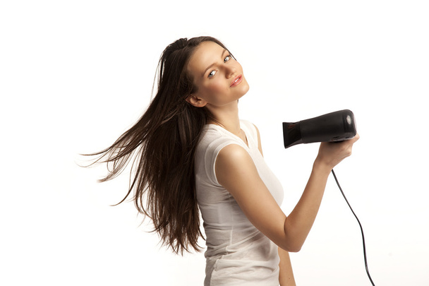 Beautiful smiling young woman drying her hair - Fotografie, Obrázek
