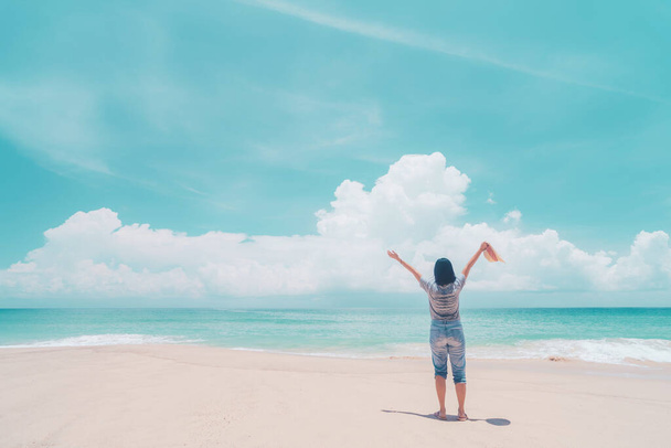 青い空を背景に熱帯のビーチで手を挙げてくれる幸せな女性。旅行休暇と自由は良い概念を感じる。ヴィンテージトーンフィルターエフェクトカラースタイル. - 写真・画像