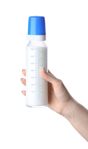 白い背景に赤ちゃんのためのミルクの女性の手保持ボトル - 写真・画像