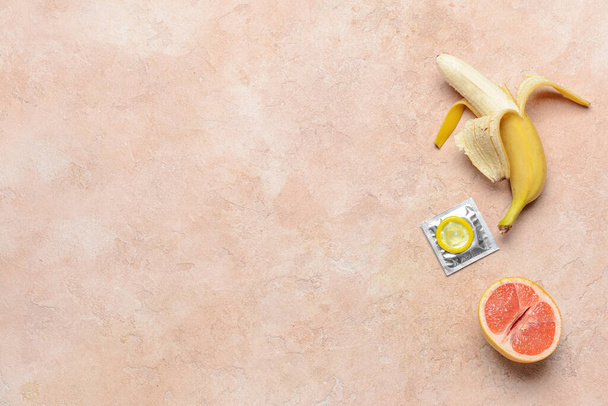 Banán és grapefruit óvszerrel a színes háttér. Erotikus fogalom - Fotó, kép