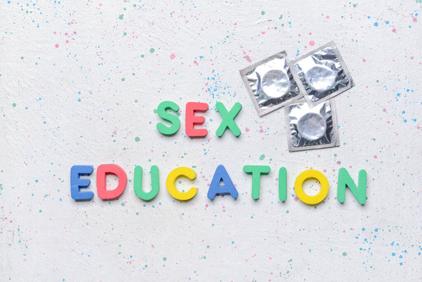 Text SEX EDUCATION with condoms on white background - Photo, Image