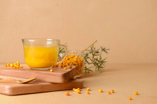 Cup of healthy sea buckthorn tea on color background - Photo, Image