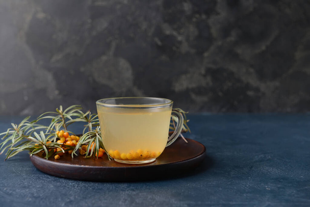 Cup of healthy sea buckthorn tea on dark background - Fotografie, Obrázek