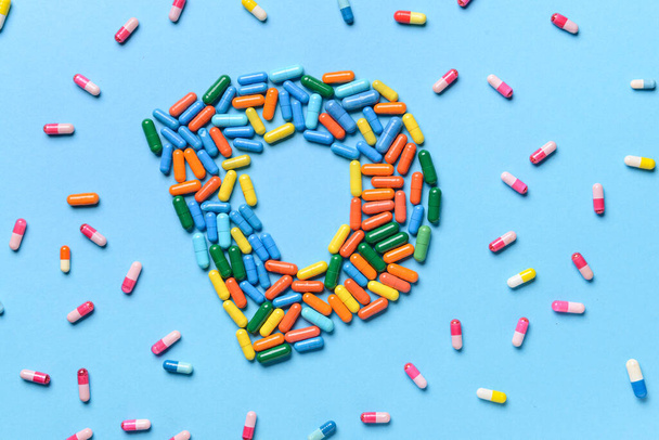 Буква D из таблеток на цветном фоне - Фото, изображение