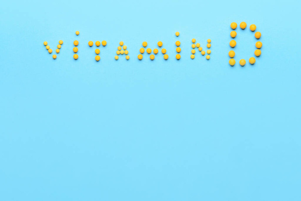 Текст VITAMIN D сделан из таблеток на цветном фоне - Фото, изображение