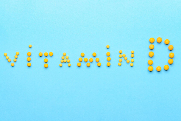 Text VITAMIN D made of pills on color background - Foto, afbeelding