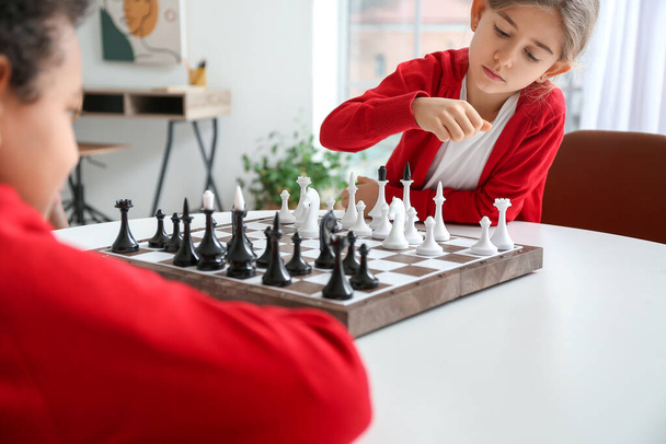 Милые дети играют в шахматы дома - Фото, изображение