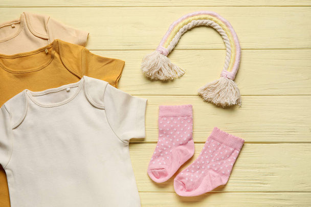 Baby clothes and socks on color wooden background - Photo, Image