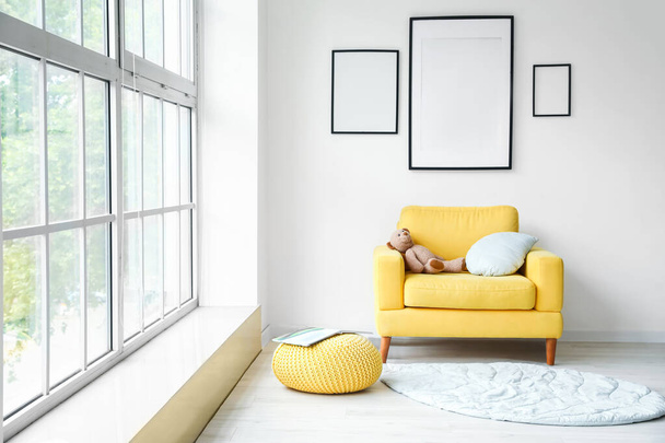 Interior of modern stylish room with armchair and blank photo frames - Fotó, kép