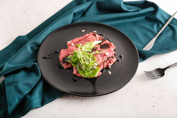 Plate with tasty veal carpaccio on light background - Foto, imagen