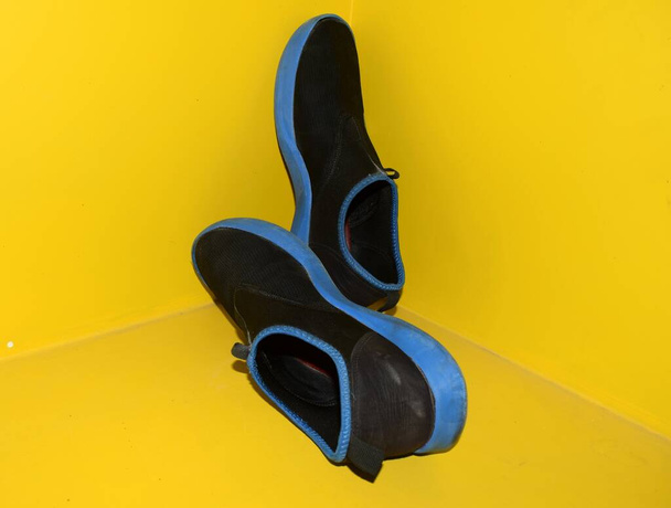 zapatillas deportivas negras sobre fondo amarillo - Foto, imagen