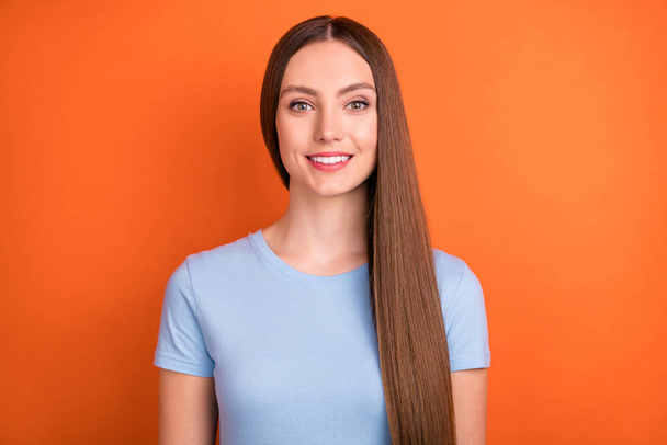 Photo of joyful brown hairdo young lady wear blue t-shirt isolated on vivid orange color background - Foto, imagen