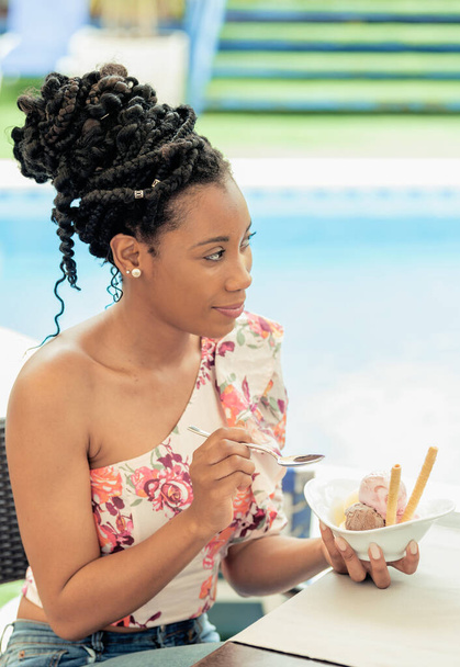 Afro american woman smiling and eating a sugar free ice cream desert - Fotó, kép